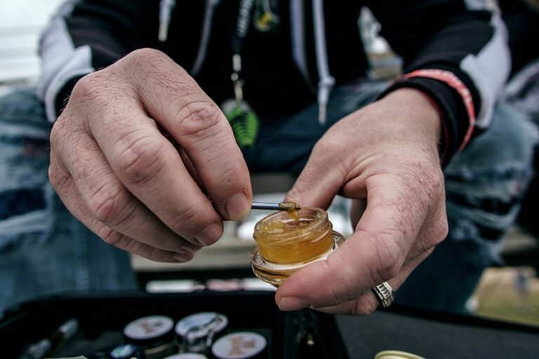 A man showing thca sand's different uses for smoking and vaping.
