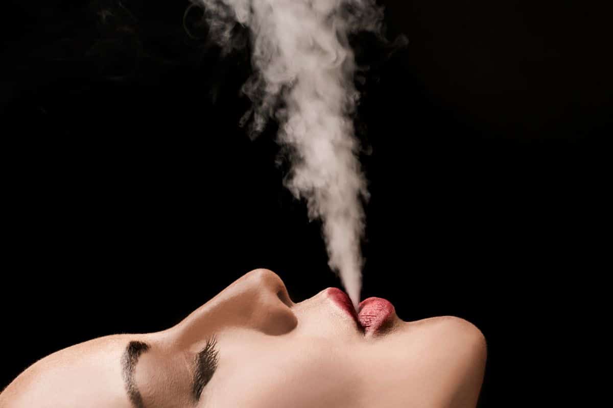 A girl focusing and smoking delta 8