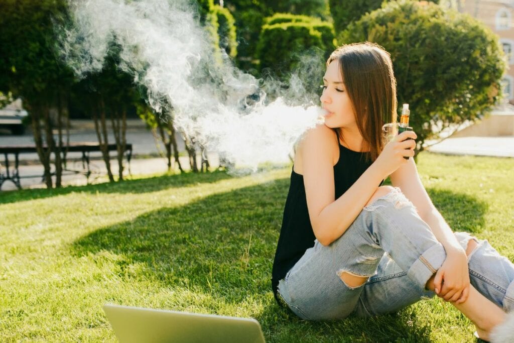 A girl vaping outdoors