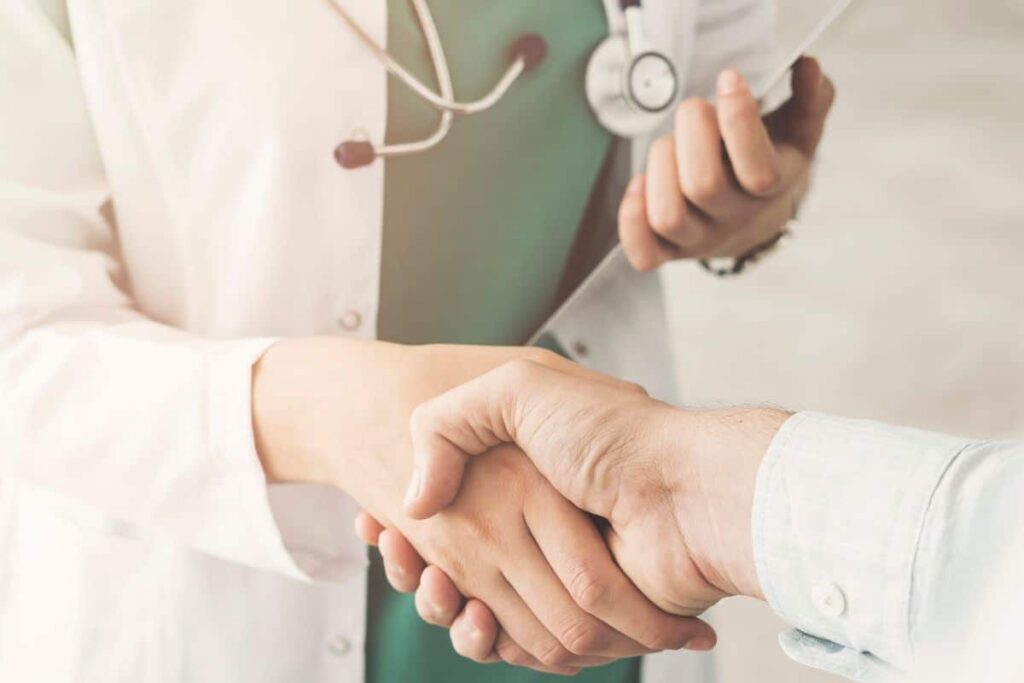 A doctor shaking hands with the patient