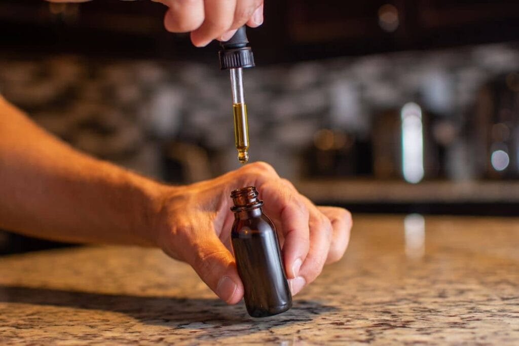 A guy holding delta 8 tincture bottle