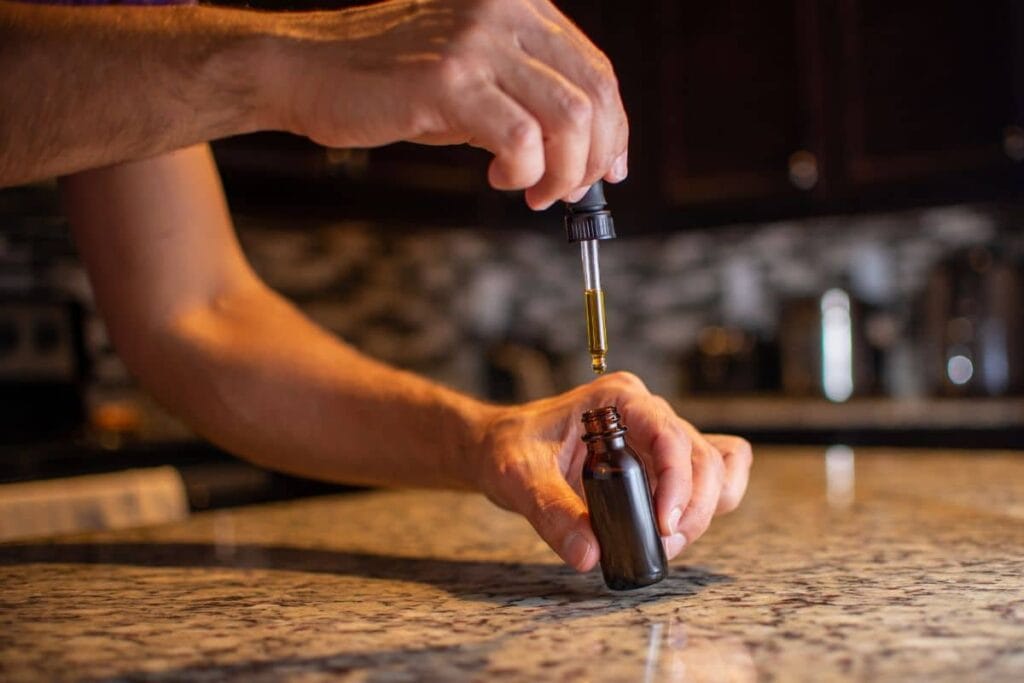 A guy holding Delta 8 Tincture Bottle in his hand