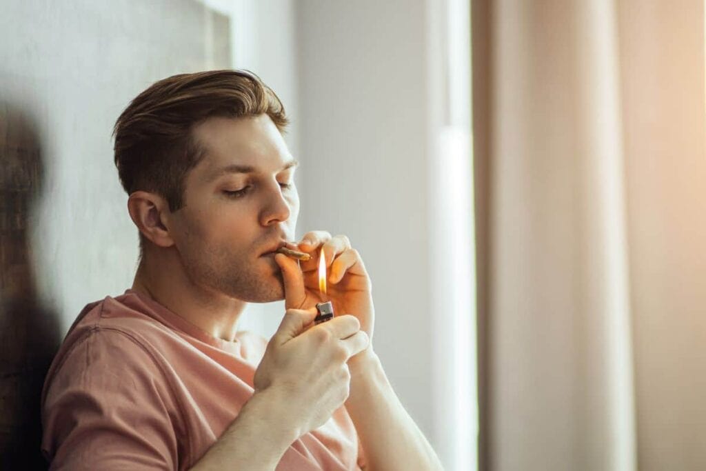 A guy smoking a joint and getting ready for playing video games