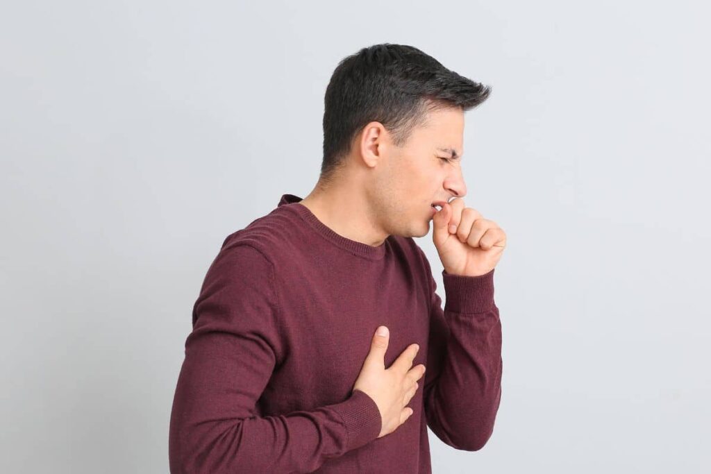 A man coughing after vaping