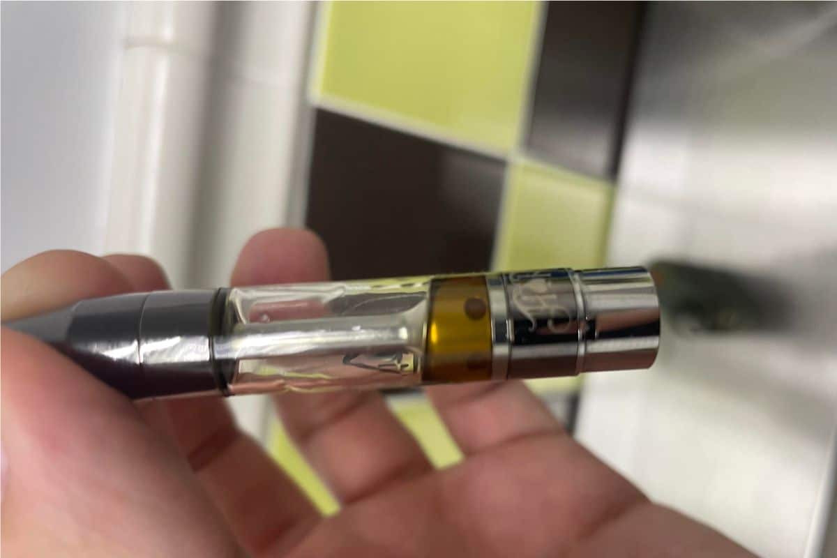 A guy holding a burnt vape cart