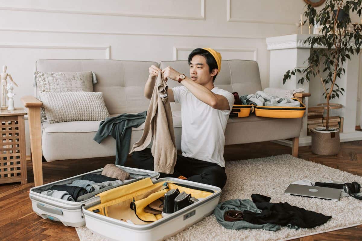 A guy packing his bag for travel with delta 8 vaping products