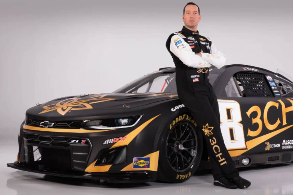 A man next to a Chevrolet NASCAR car showing 3chi logos