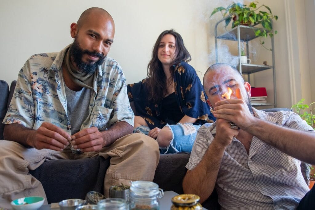 Two guys smoking weed in front of their non smoker friend