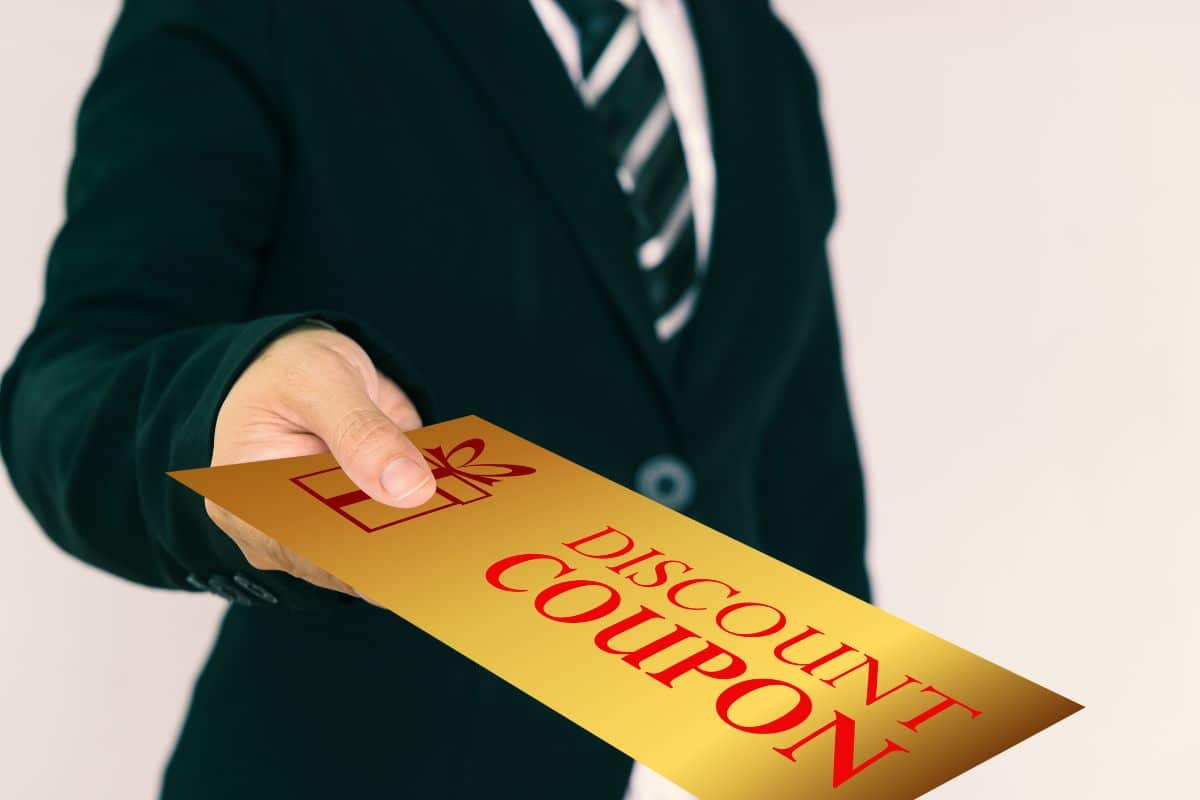 A guy holding discount coupon in his hand for vaping products