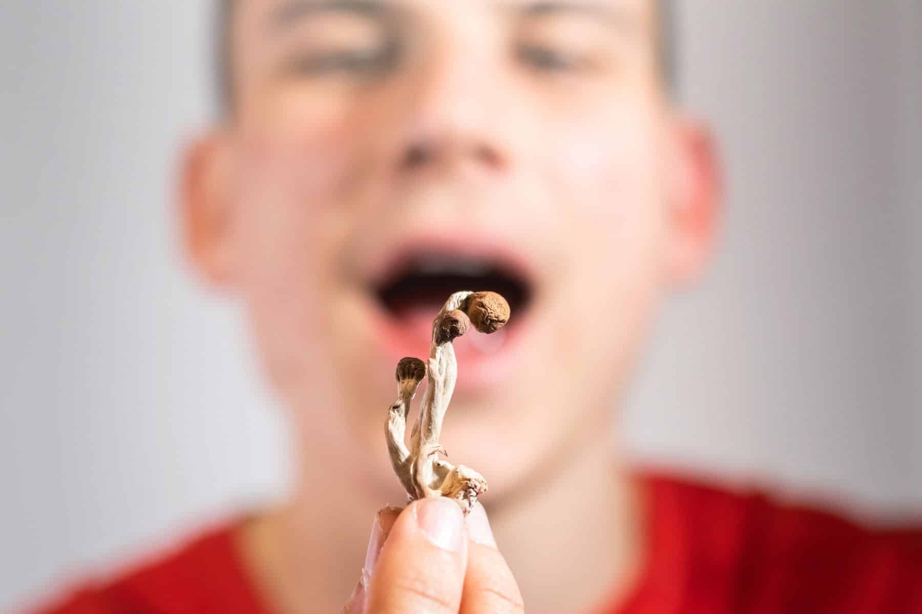 A man holding magic mushroom with his three fingers