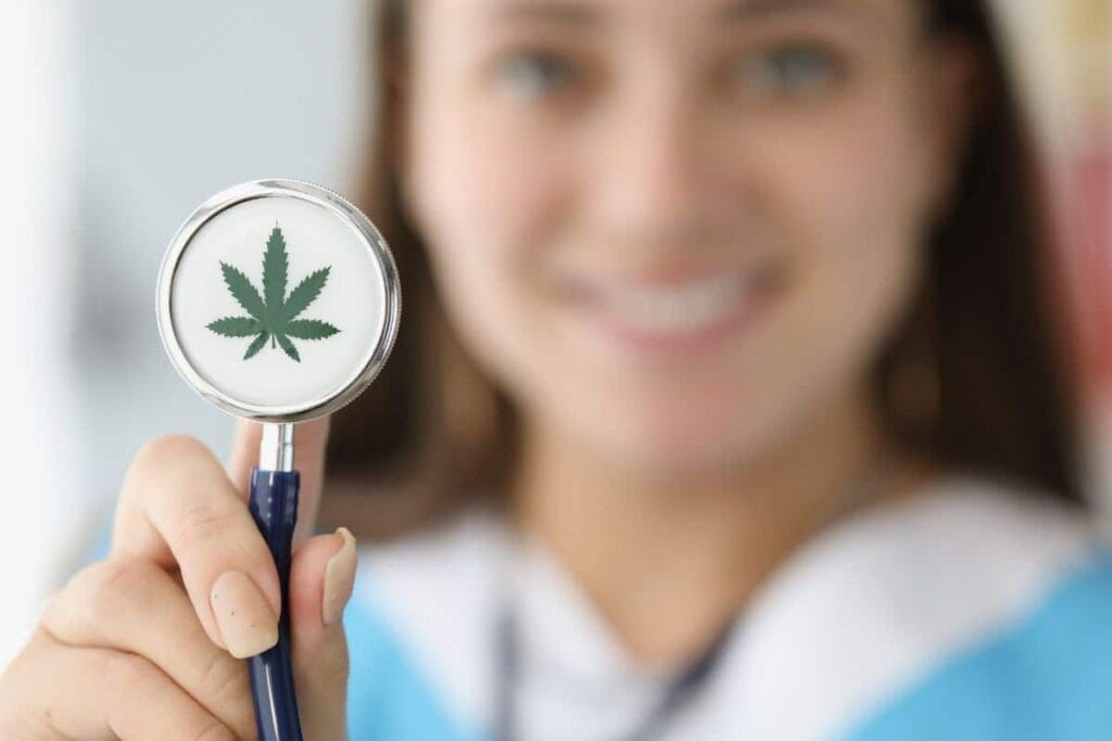 A nurse holding up a stethoscope adorned with a marijuana leaf, discussing the legality of THCa in California.