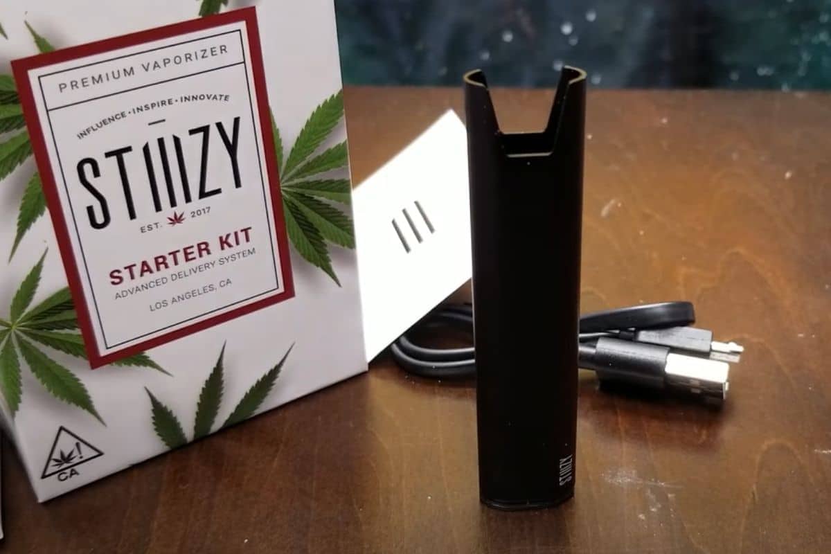 The stizzy starter kit, containing the strongest stiiizy pod, is sitting on a table next to a box.