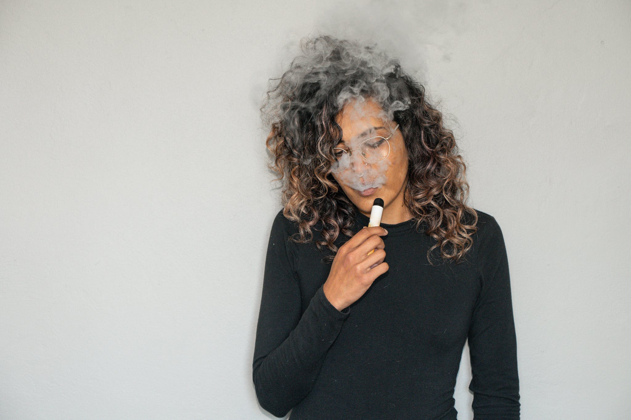 A Woman using Vape without a pen