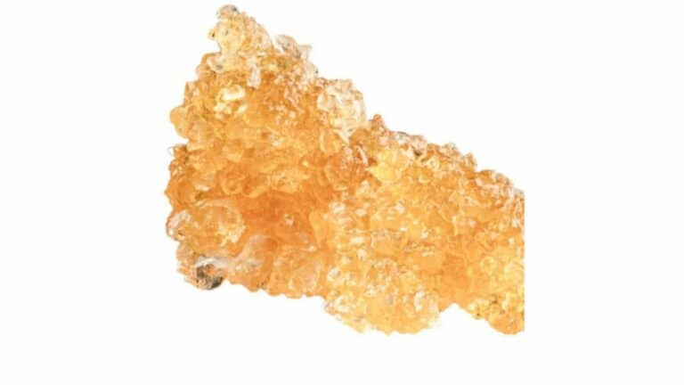 A potent THCa diamond, a cannabis extract, on a white background.