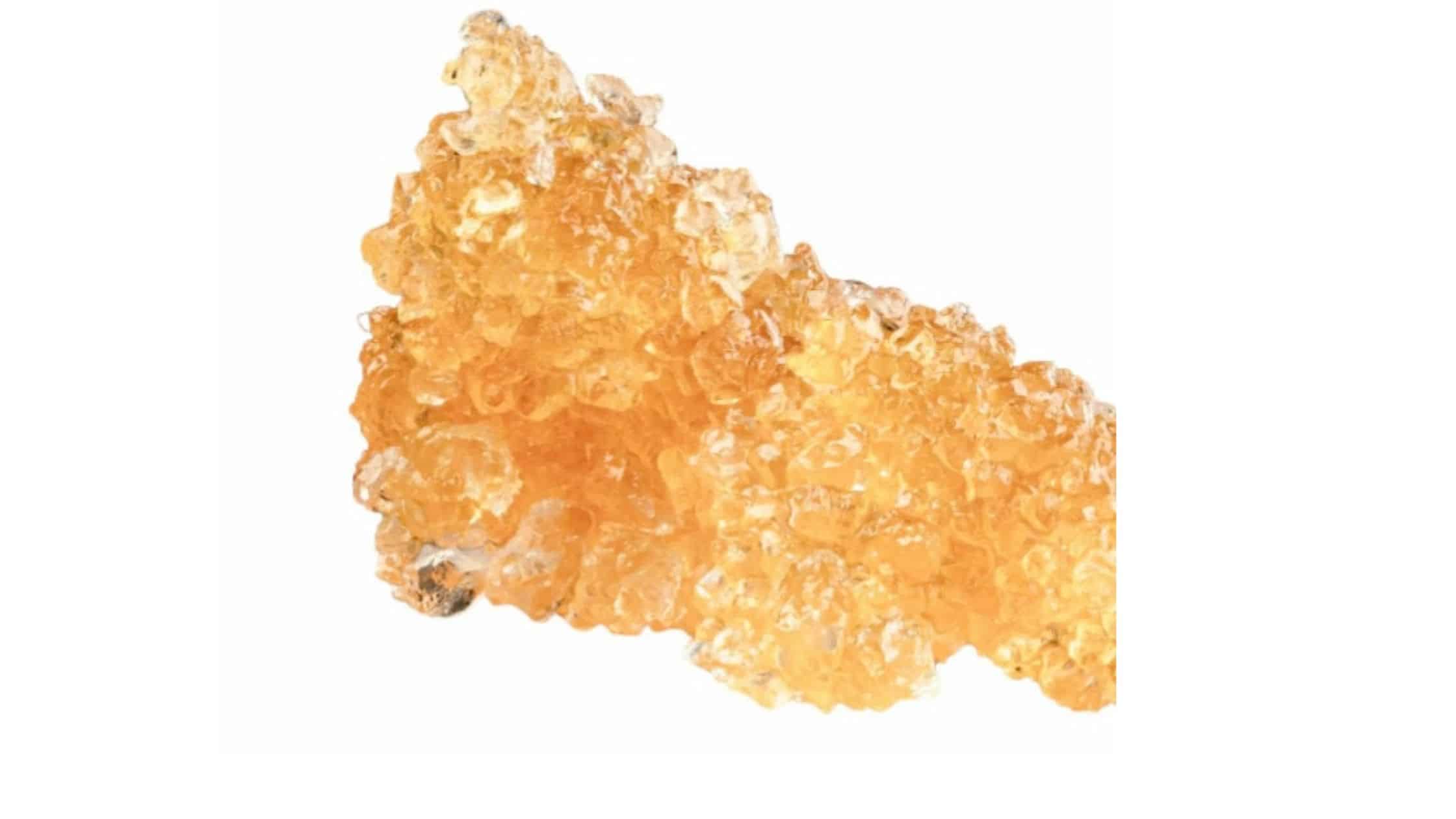 A potent THCa diamond, a cannabis extract, on a white background.