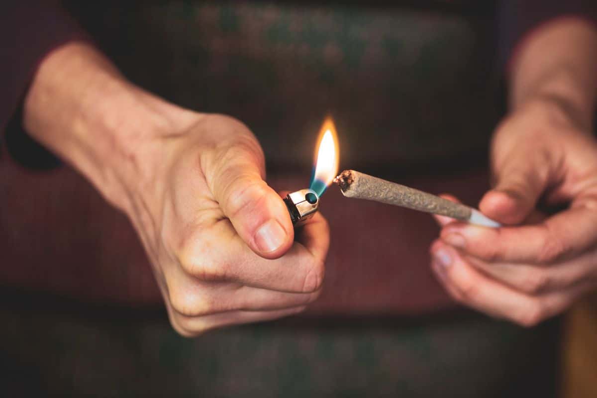 A guy lighting up a pre roll