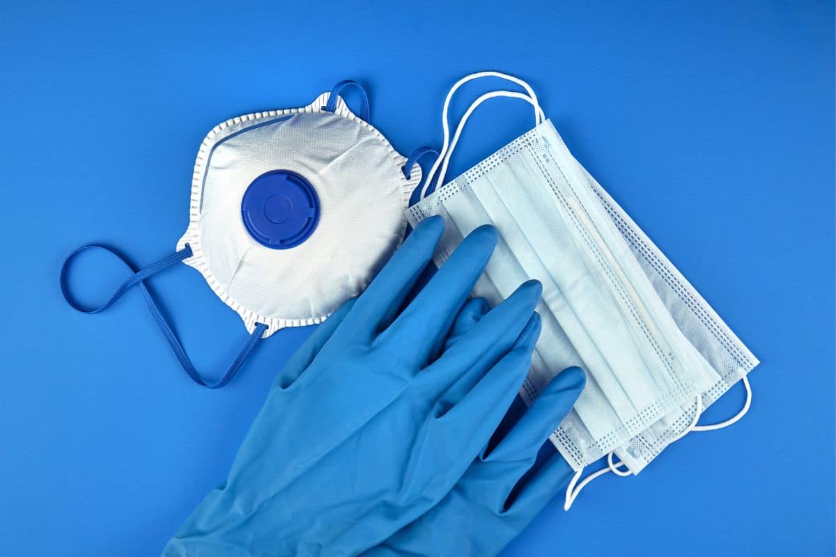 A pair of gloves and a surgical mask on a blue background, demonstrating how to use dazed 8 disposable.