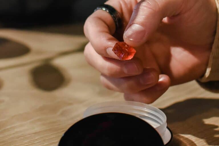 A woman holding live resin gummy in her hand