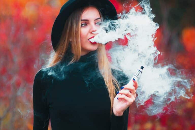 A woman vaping delta 8 thc outdoors