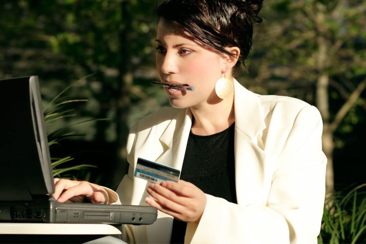 A woman with a laptop and ATM card is purchasing Blunts online