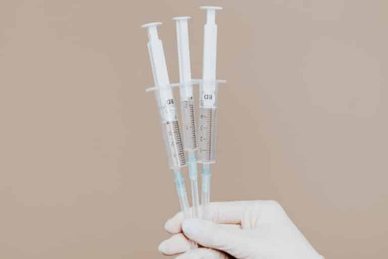 A step-by-step guide on using distillate syringes, showcased through a hand holding three syringes on a brown background.