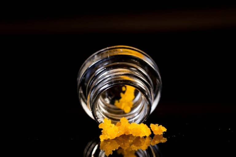 Weed budder on the surface coming out from a container.