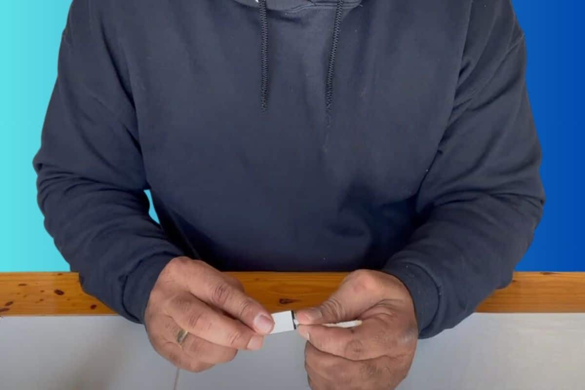 A guy cleaning mouthpiece of disposable vape.