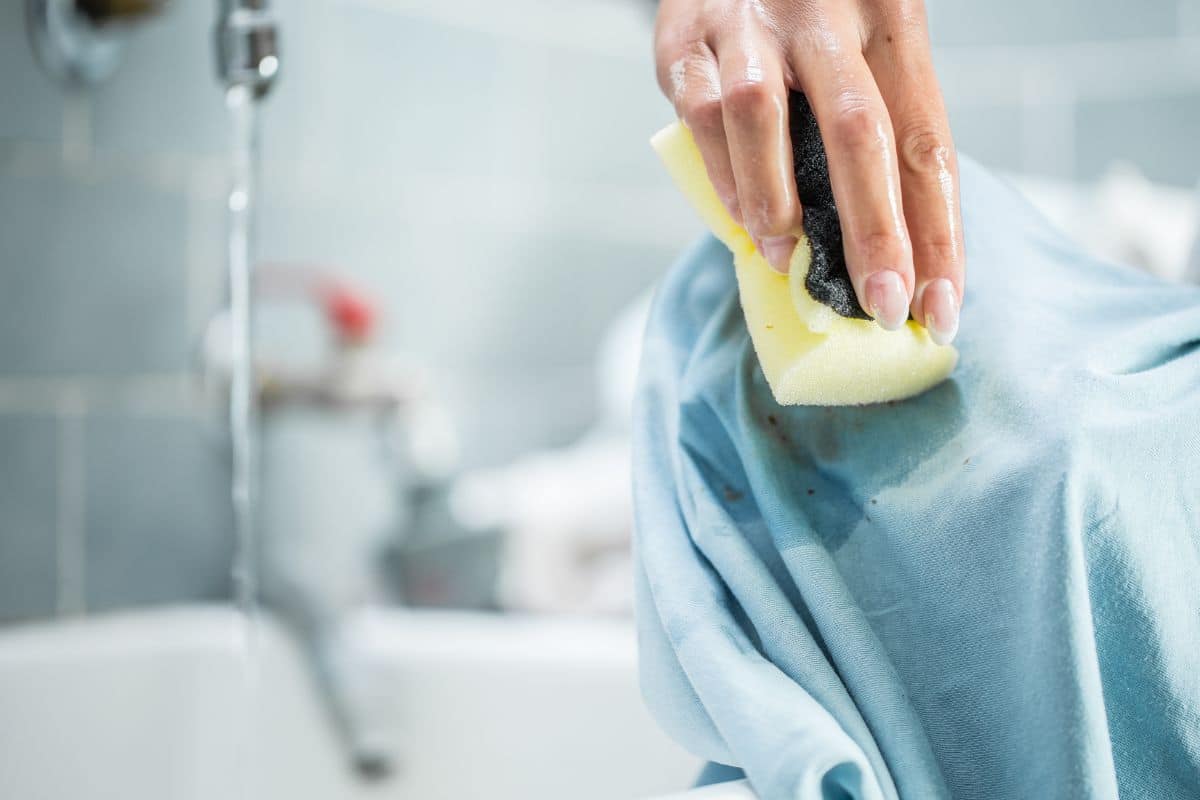 A lady trying to Blot the vape juice stain and using cold water to remove it.