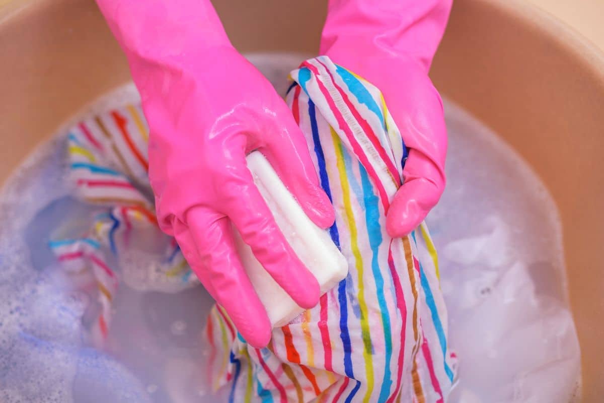 A lady using dish soap to remove vape juice stain from her cloth