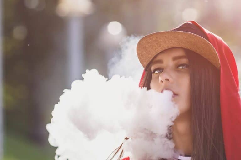 A lady using throat hitting disposable vape
