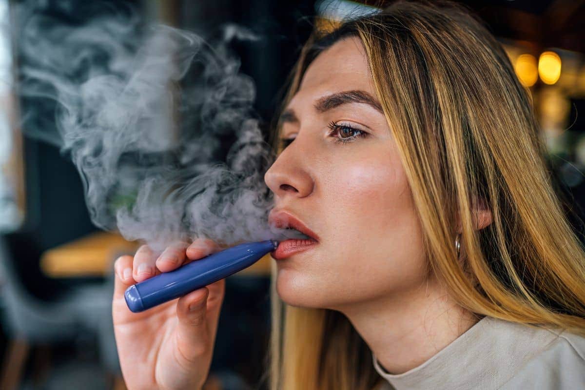 A lady vaping and counting the puffs she took.