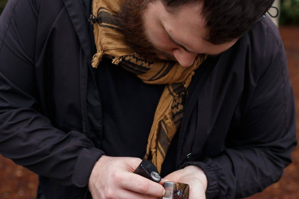 A man accidentally spill vape juice on his sleeves and watching how it get spilled.