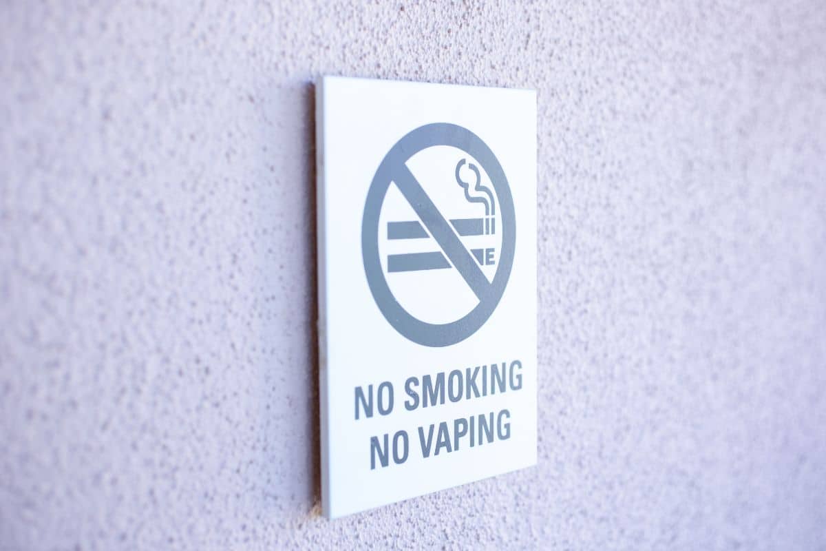 No smoking, no vaping, no e-cigarettes" sign mounted on a wall of the international airport