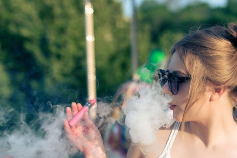A lady is vaping delta 8 thc vape