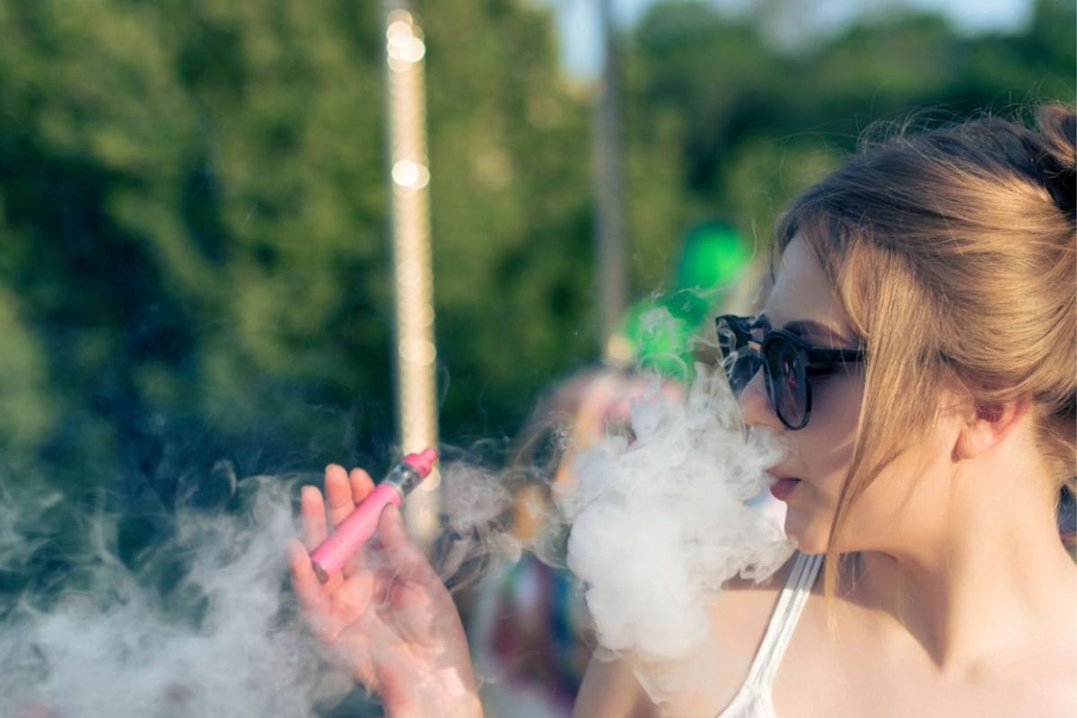 A lady is vaping delta 8 thc vape