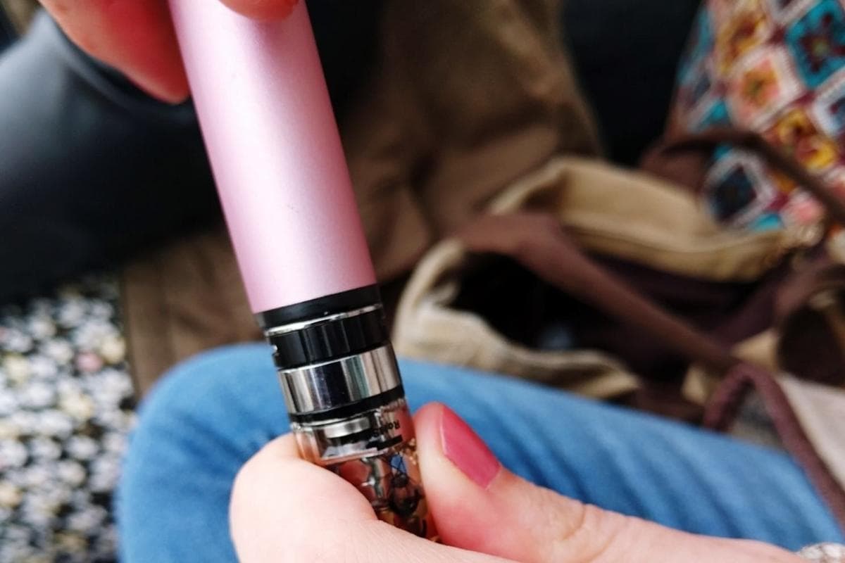 A woman removing a cartridge from her dab pen