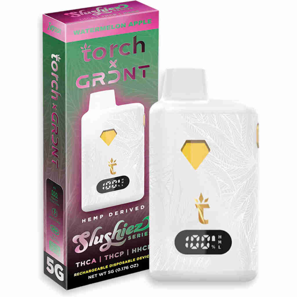 Image of a white, rectangular THCa Disposable vape device with gold accents, displayed next to its colorful packaging. The Torch x GRDNT package belongs to the Slushie Series. Flavor indicated is Watermelon Apple. Device features a digital display and leaf pattern.