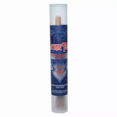 A cylindrical container features a dark blue label with red and white text reading Smokin Tenns THCa Pre-Roll 2g - Berry Blue OG. It has transparent sections at the top and bottom, revealing a wooden tip inside.