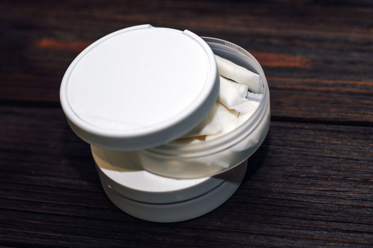 Nicotine pouches inside its container kept on a wooden table