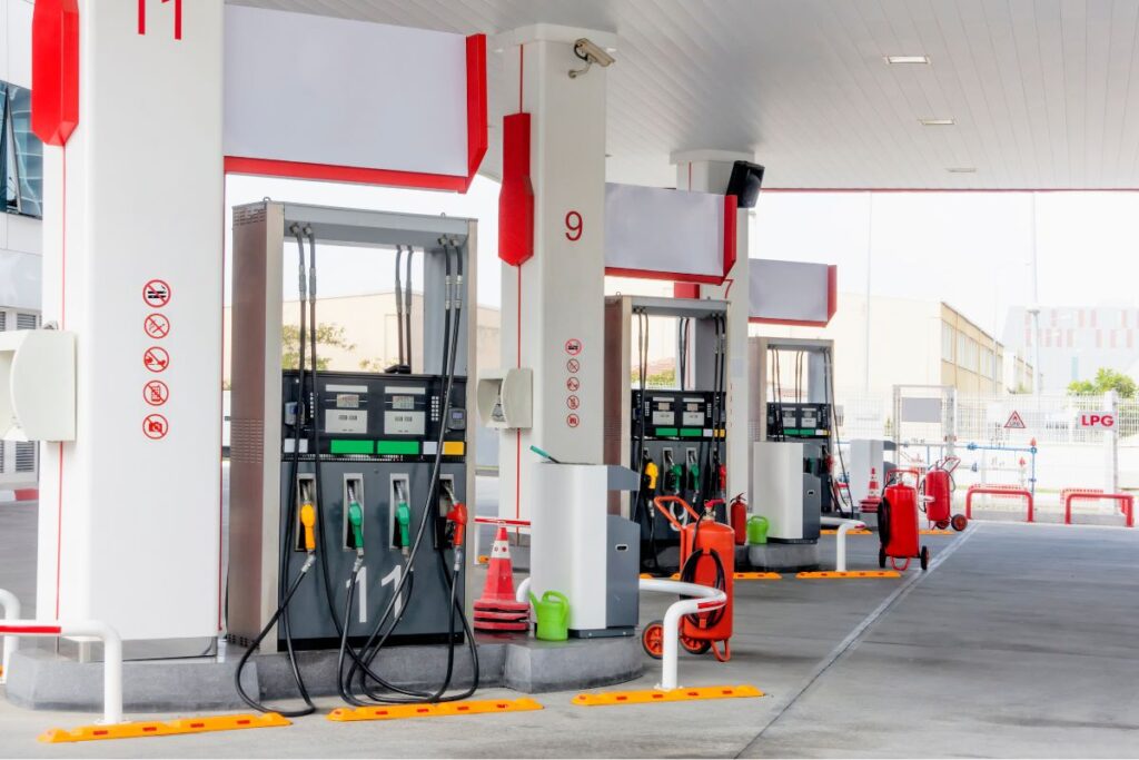 A 'No Vaping' and 'No Smoking' sign, along with other precautions, is posted in the petrol pump area