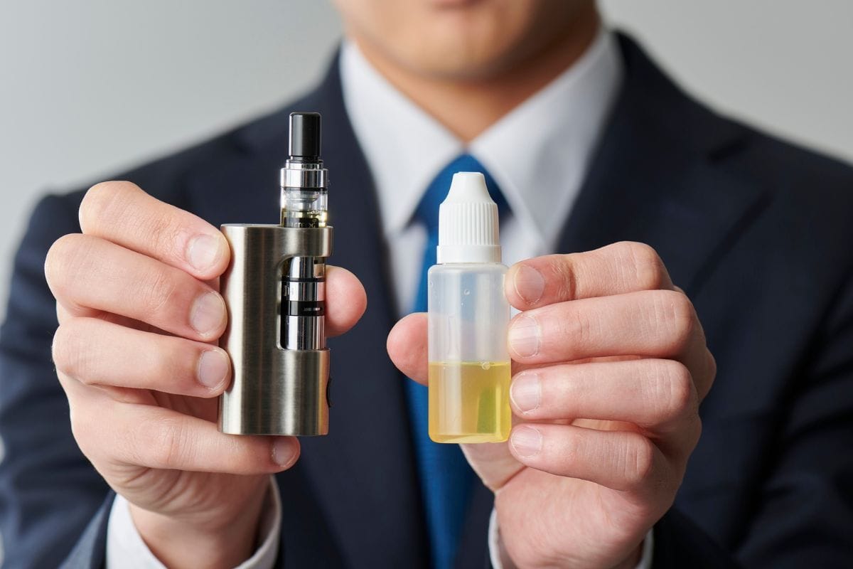 A person showing his vape and its e-liquid