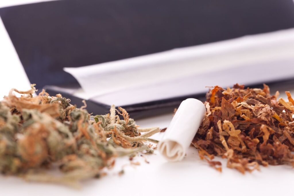 The image shows a perfectly folded crutch alongside other smoking materials