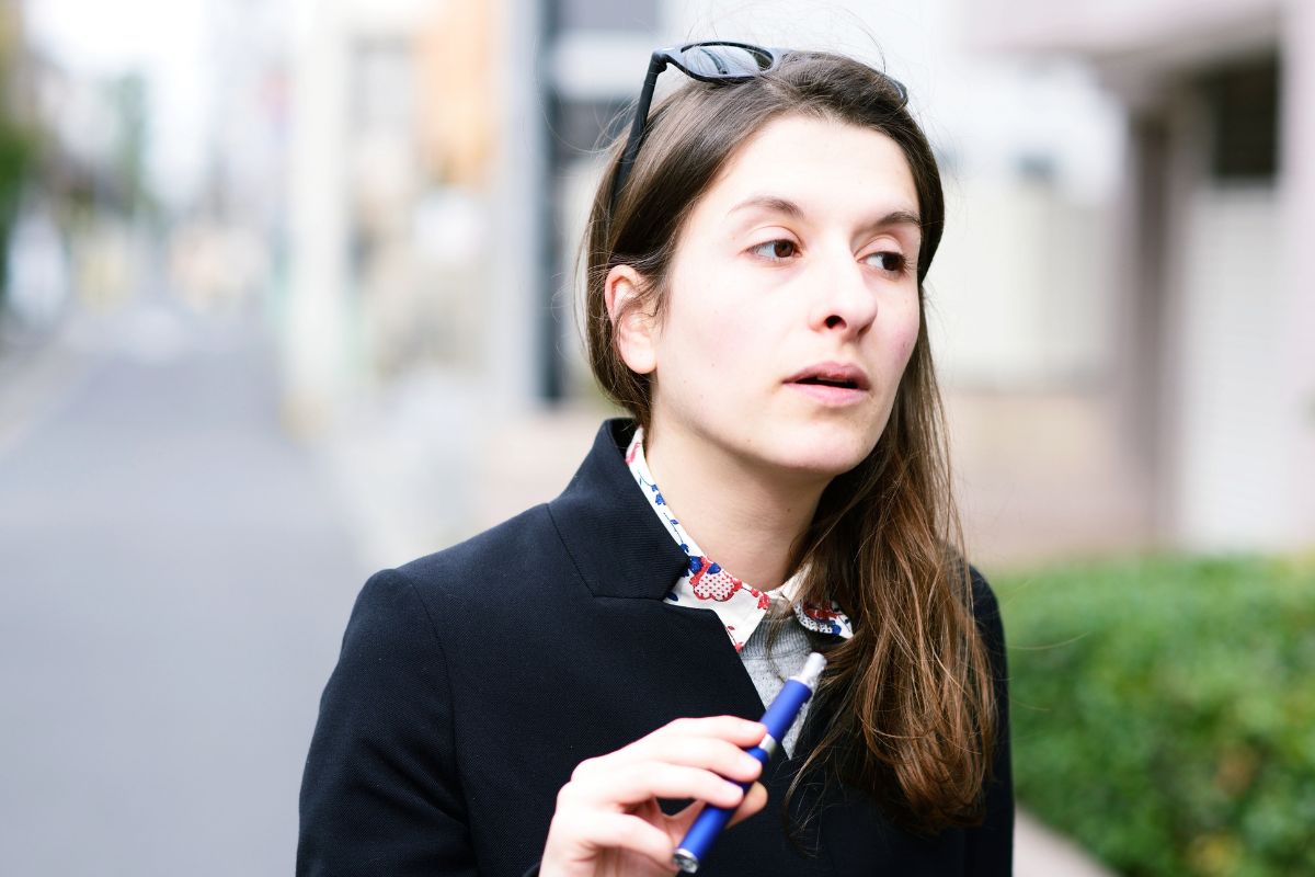 A lady vaping while producing minimal vapor