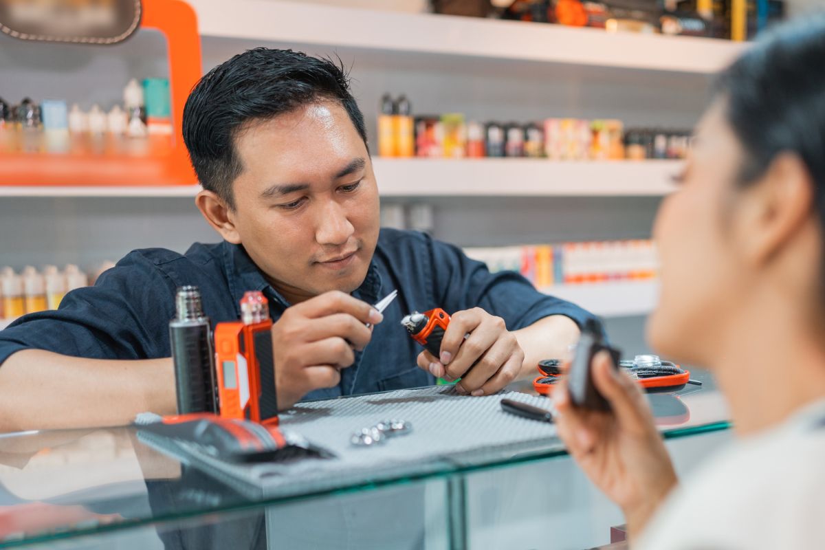 A person cleaning a clogged vape