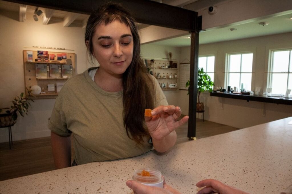 A lady taking a small amount of THC gummies for microdosing