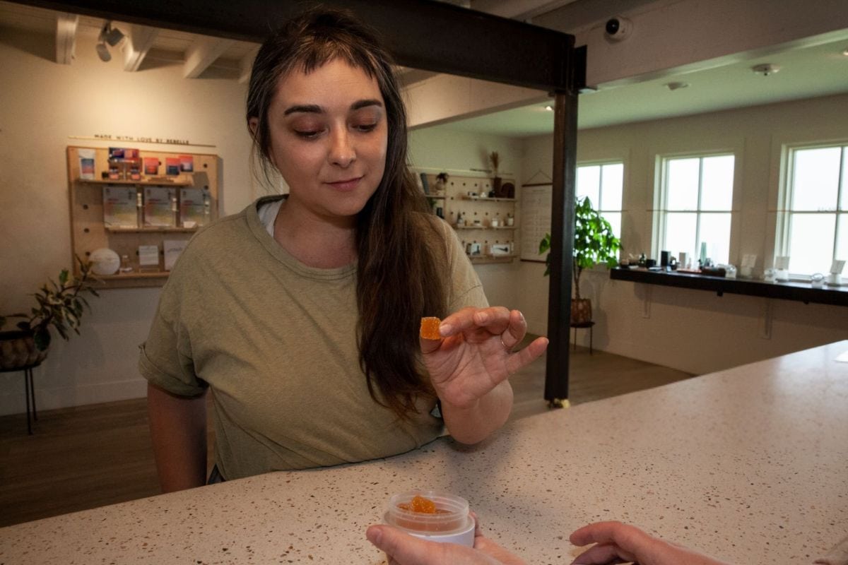 A lady taking a small amount of THC gummies for microdosing