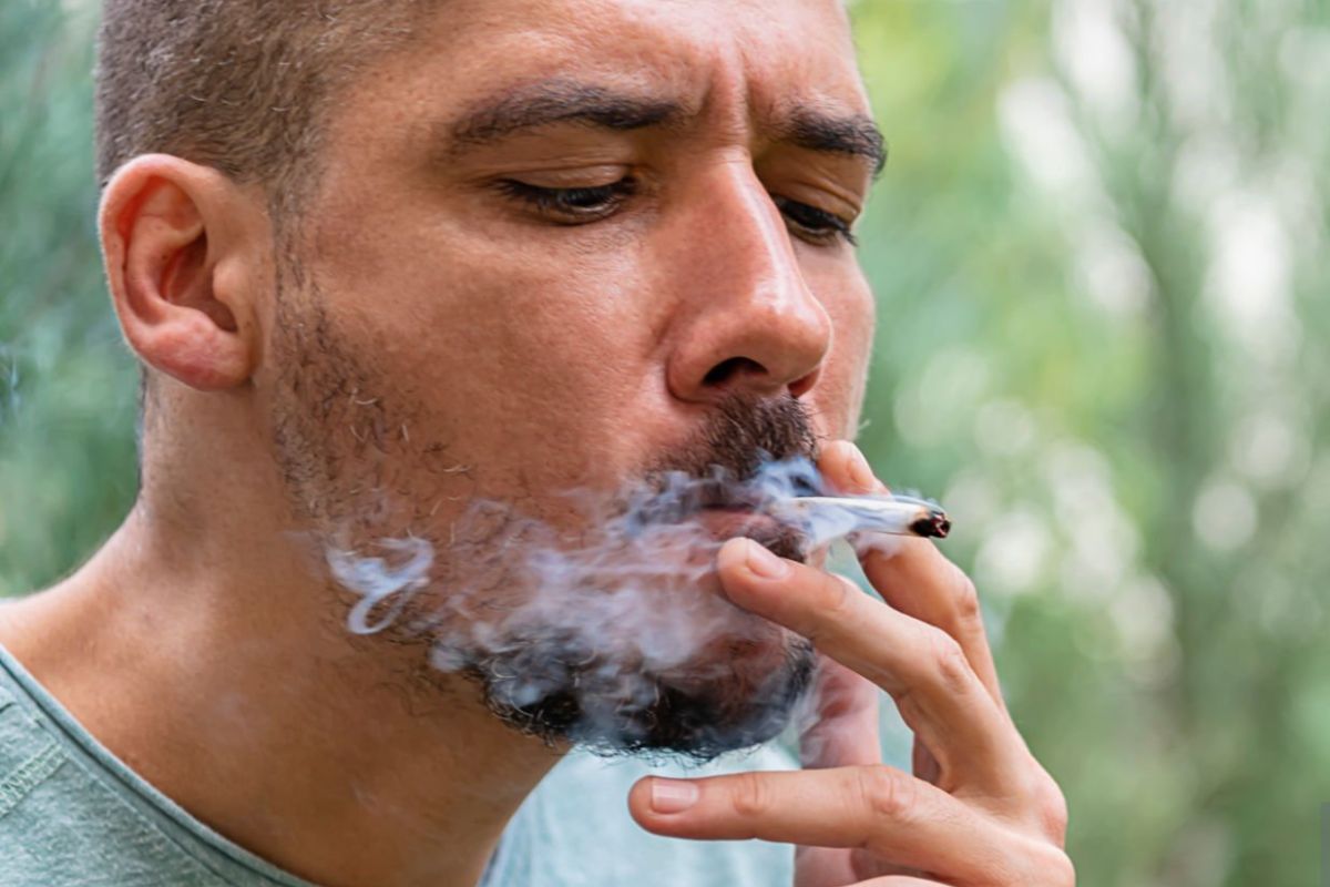 A person is smoking a cannabis pre-roll and feeling relaxed