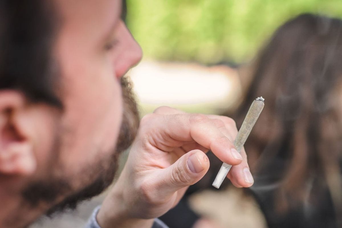 A person smoking a Sativa strain pre-roll