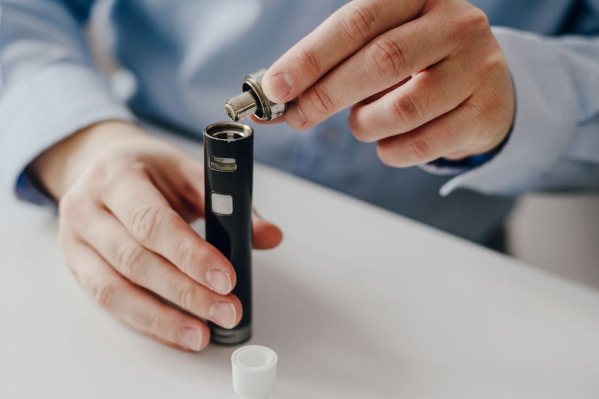 A person takes out the vape cartridge to use the concentrate for dabbing