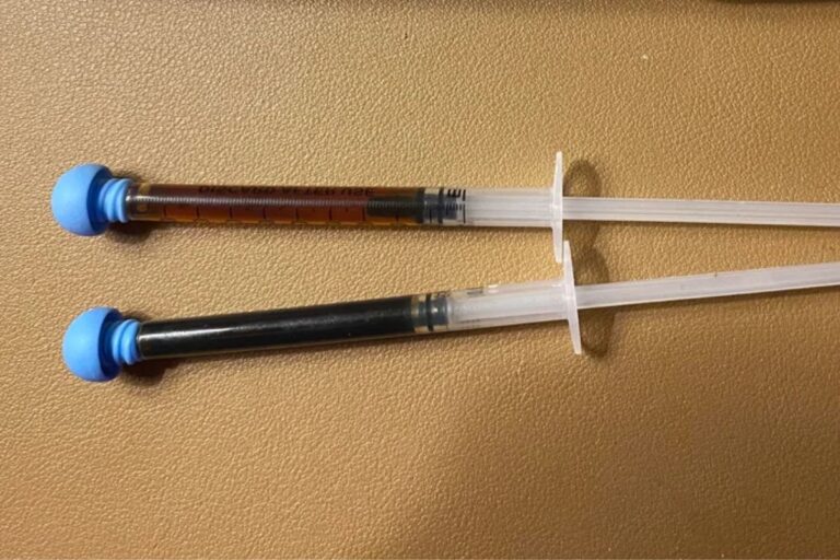 Two syringes of RSO cannabis oil placed side by side